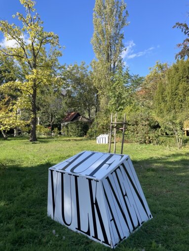 Die Installation mit Schillers Küche im Hintergrund, der ›Textbaustein‹ »Auf Vulkanen« vorn.